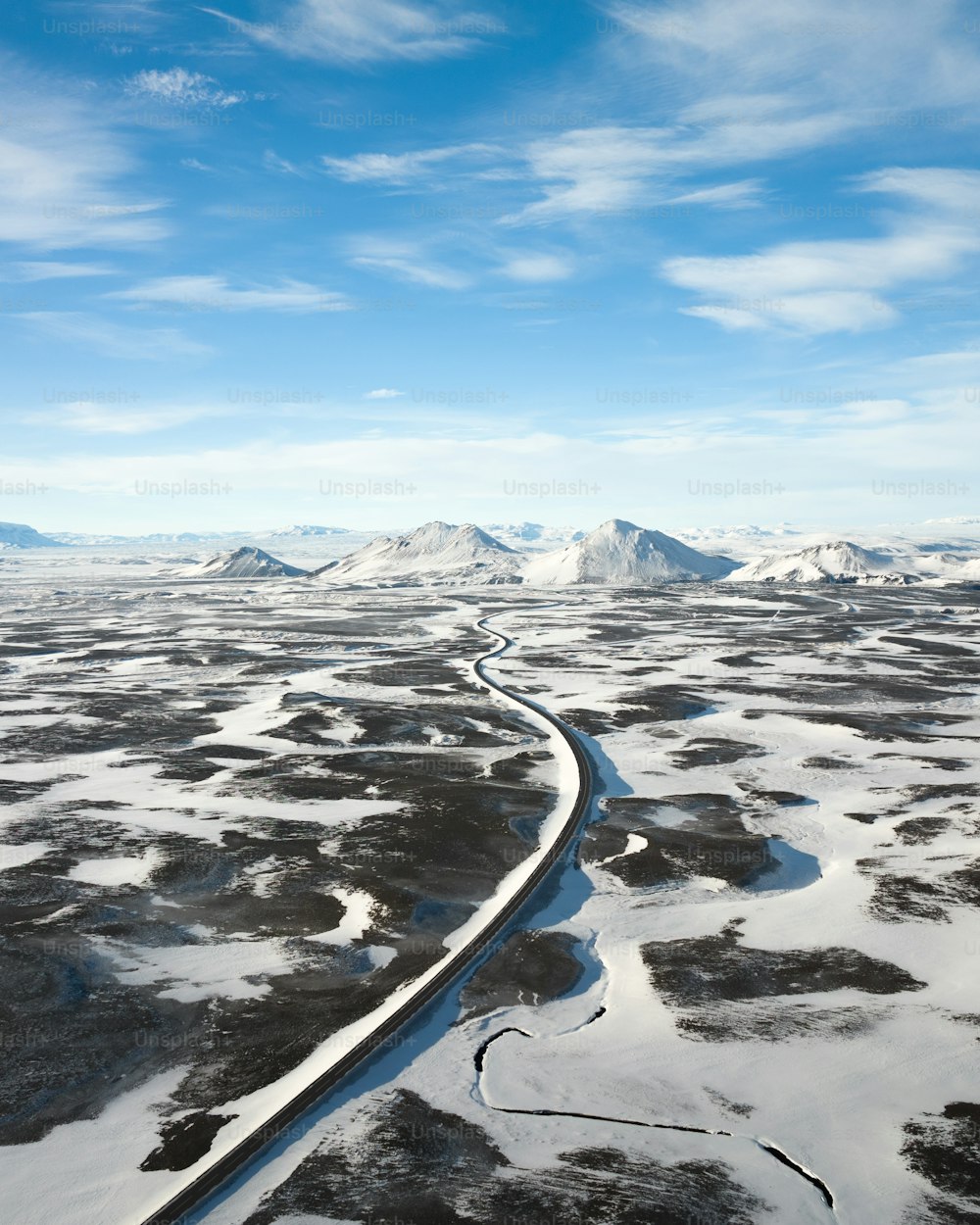 uma vista aérea de um rio que corre através de uma paisagem coberta de neve