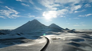 una montaña cubierta de nieve con una vía de tren que la atraviesa