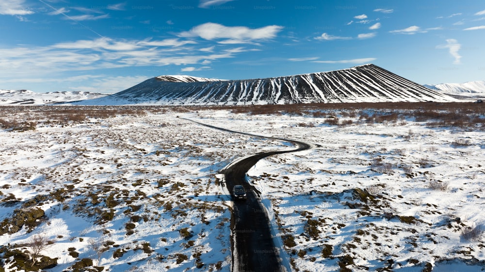 um campo coberto de neve com uma montanha ao fundo