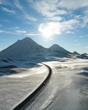 Car driving down a snowy road on a winter road trip