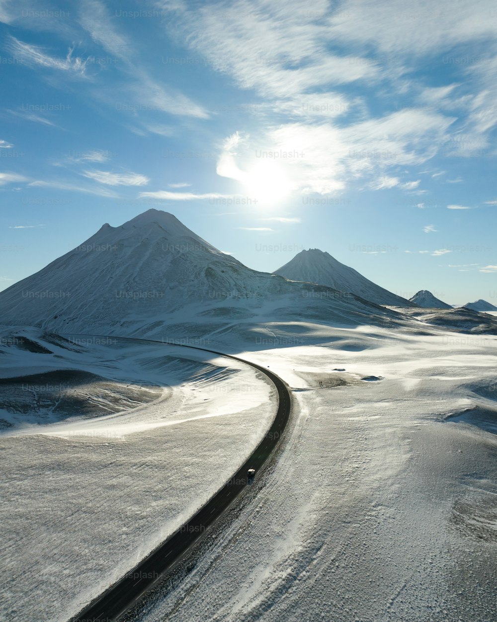 un coche conduciendo por una carretera en la nieve