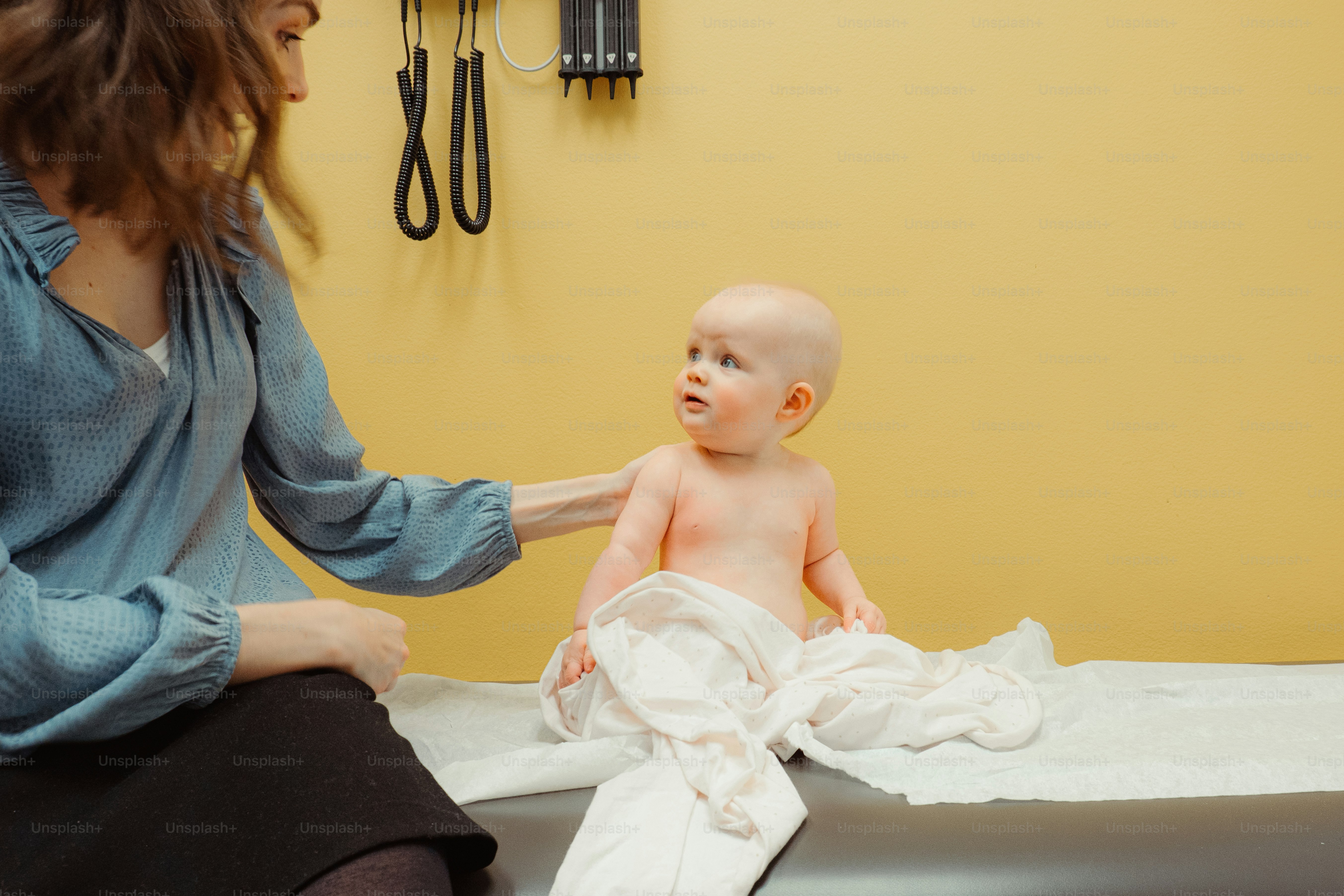 a woman holding a baby wrapped in a towel