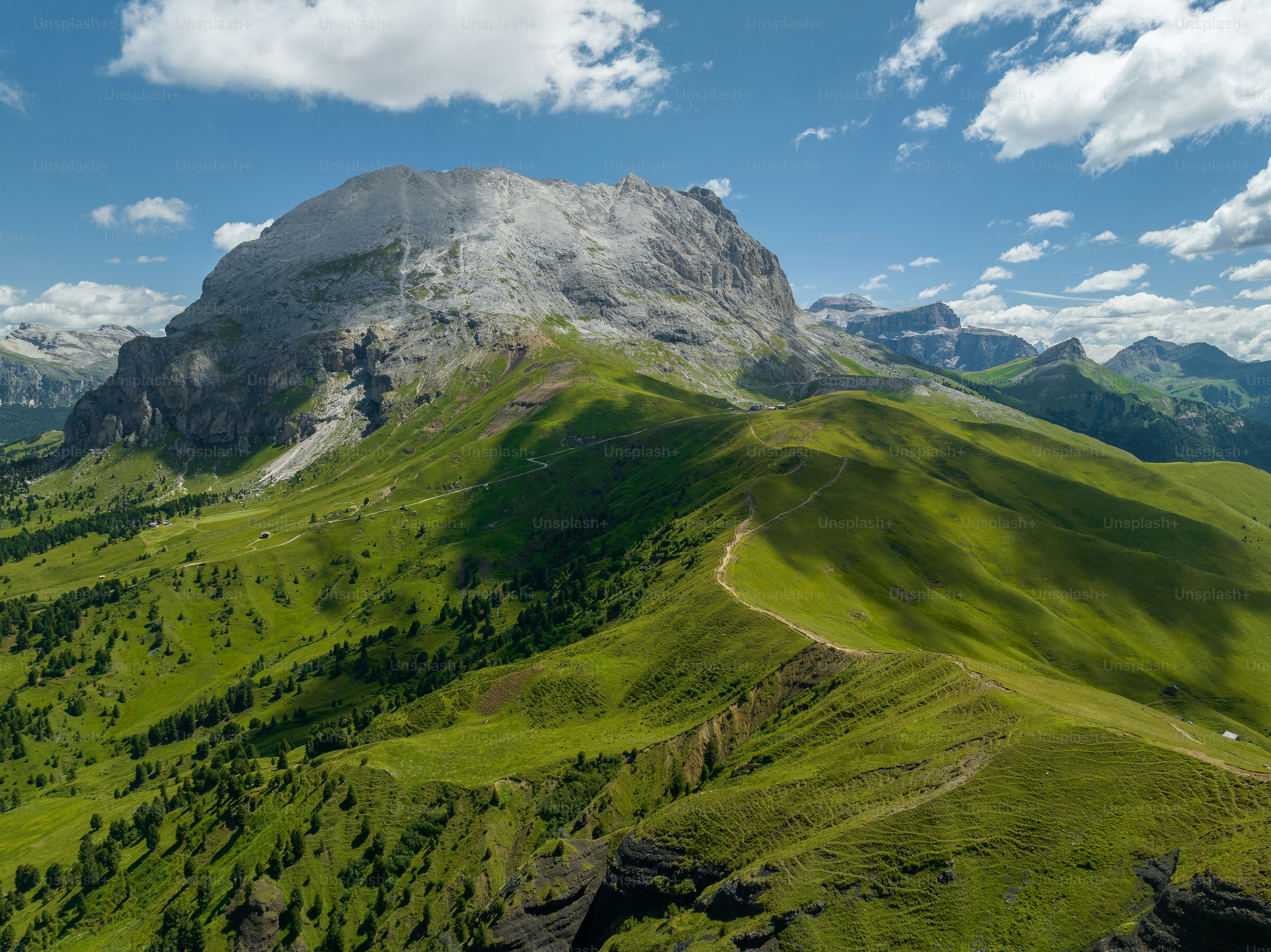 a view of a green mountain with a sky background