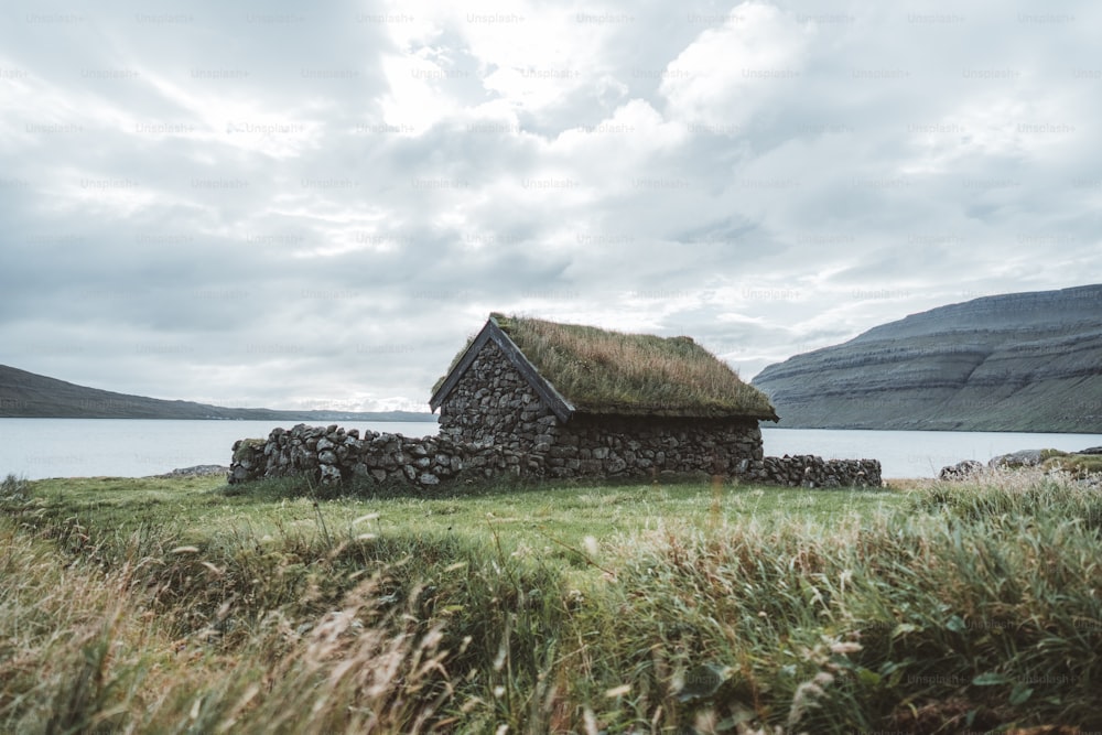 uma casa de pedra velha com um telhado de grama