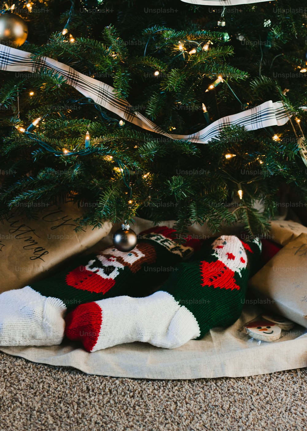 ein Weihnachtsbaum mit Geschenken darunter und ein Teddybär unter dem Baum
