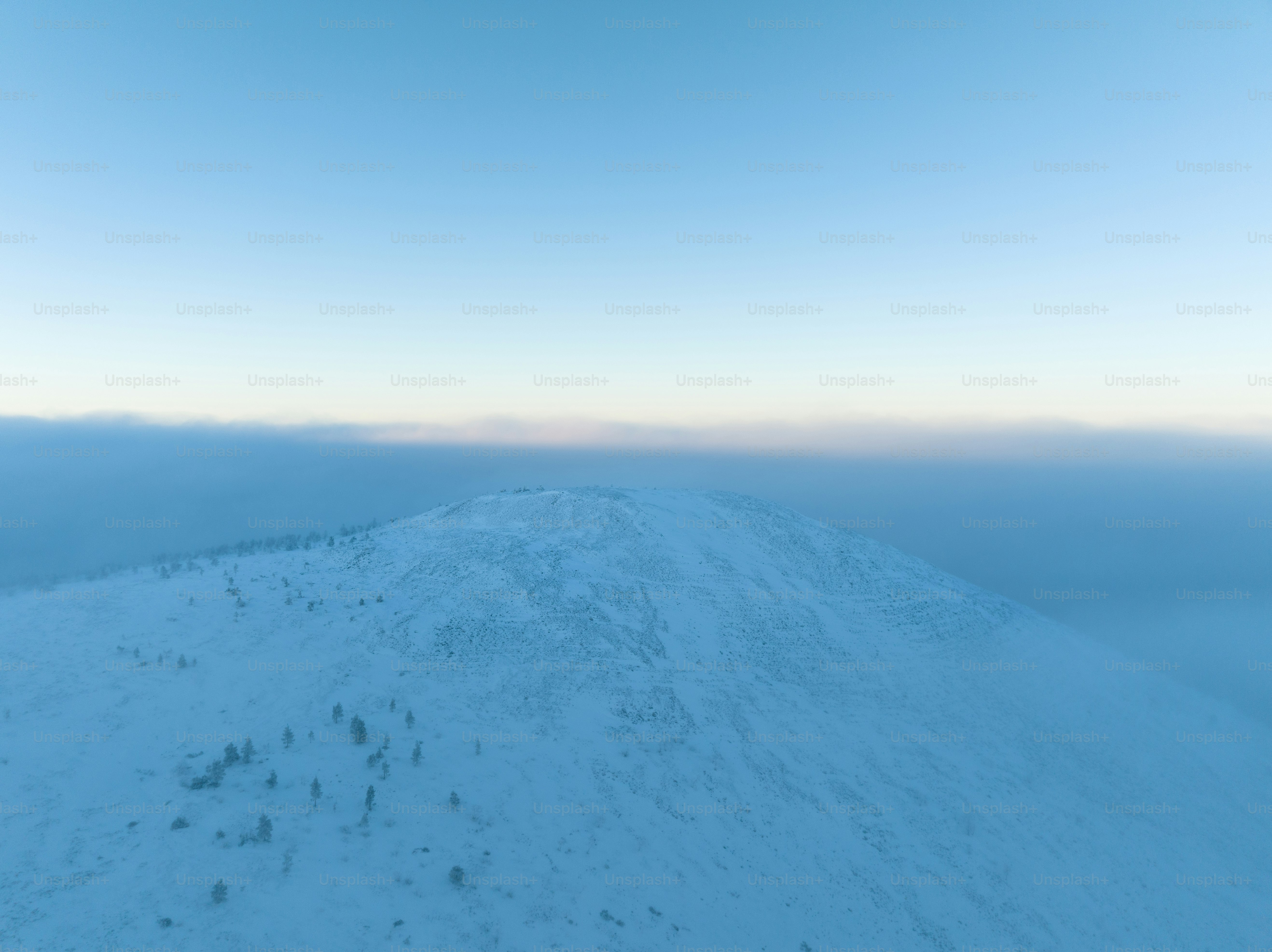 a hill covered in snow under a blue sky