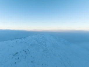 青空に覆われた雪に覆われた丘