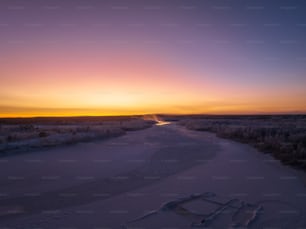 Il sole sta tramontando su un fiume ghiacciato