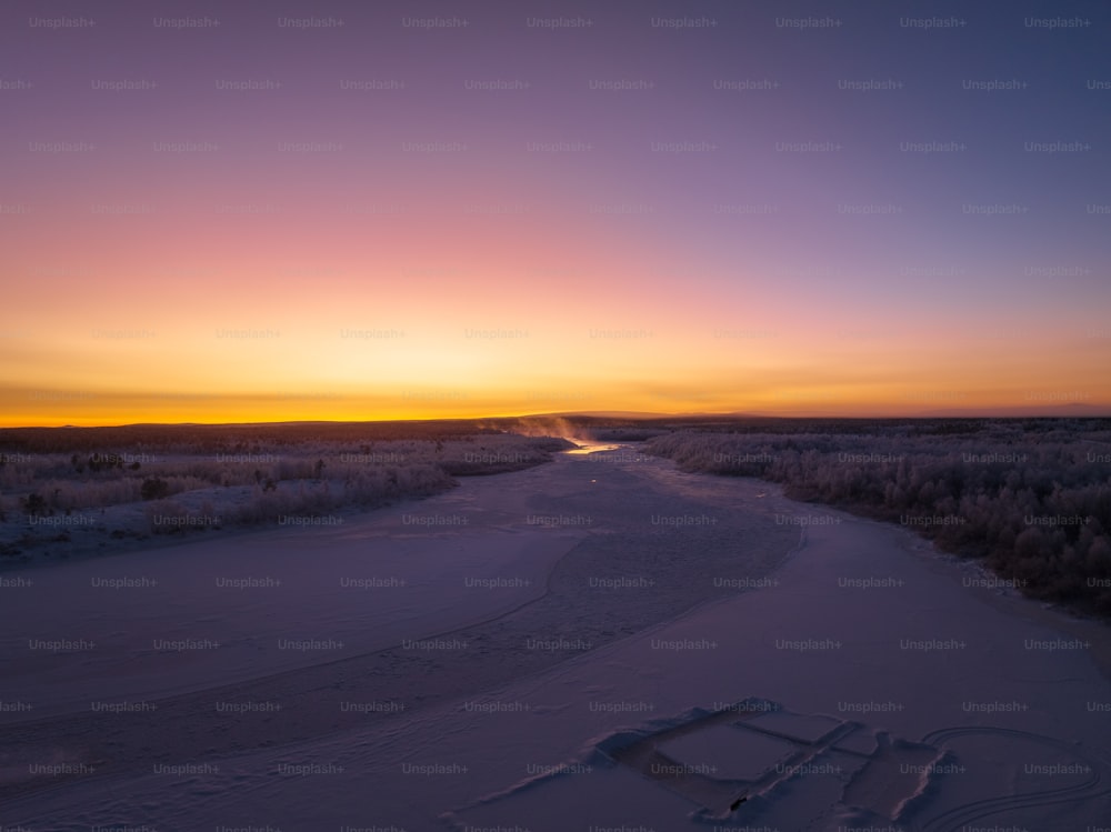 太陽は凍った川に沈んでいます