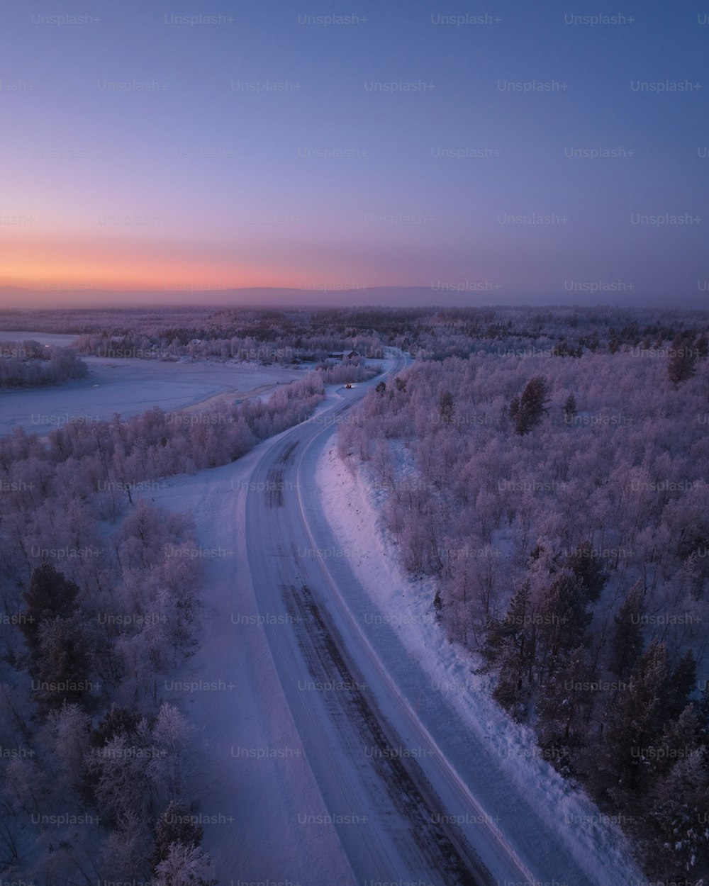 uma estrada no meio de um campo nevado