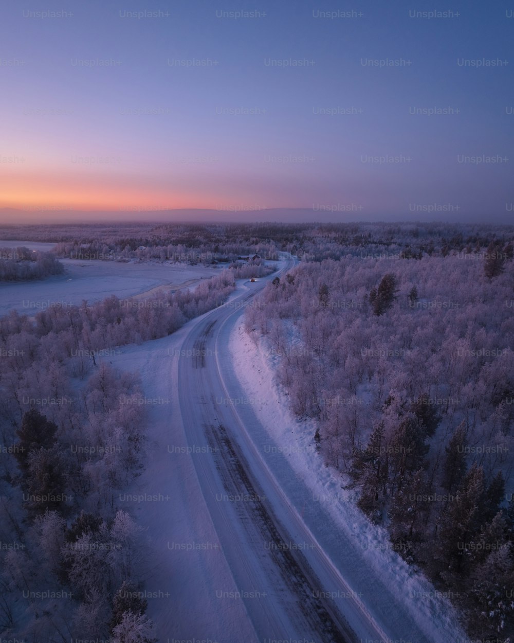 a road in the middle of a snowy field