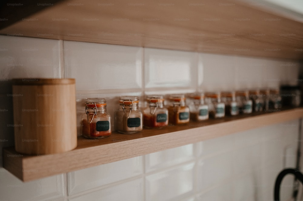 a row of jars sitting on top of a wooden shelf