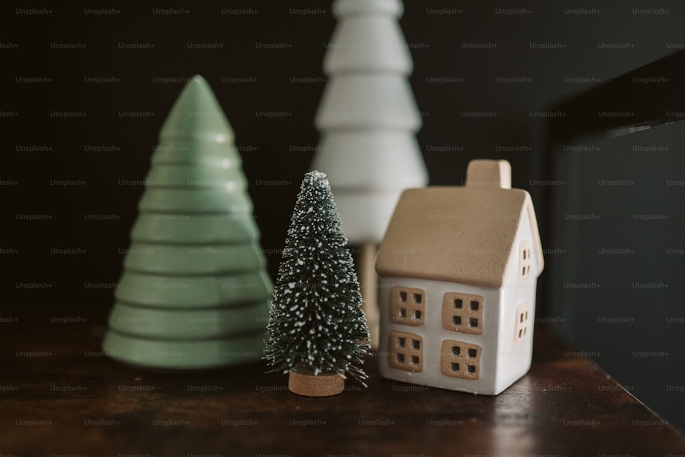 a small house next to a small christmas tree