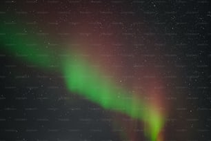 a bright green and red aurora bore in the night sky