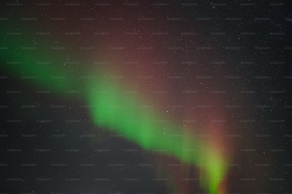 a bright green and red aurora bore in the night sky