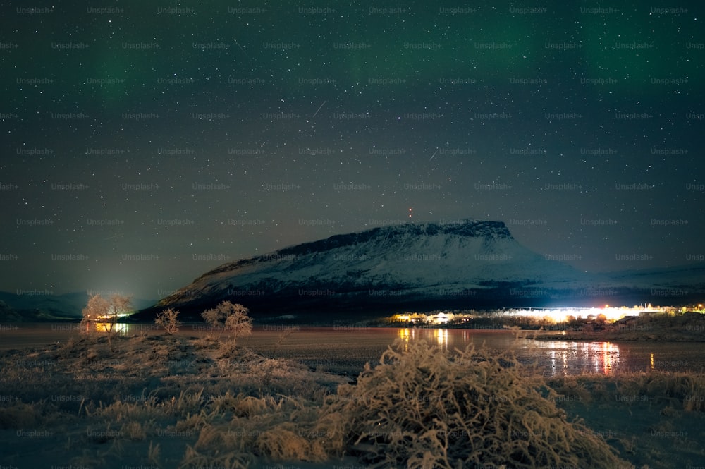 a snow covered field with a mountain in the background