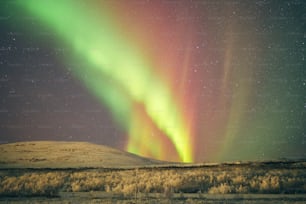 a green and red aurora bore in the night sky