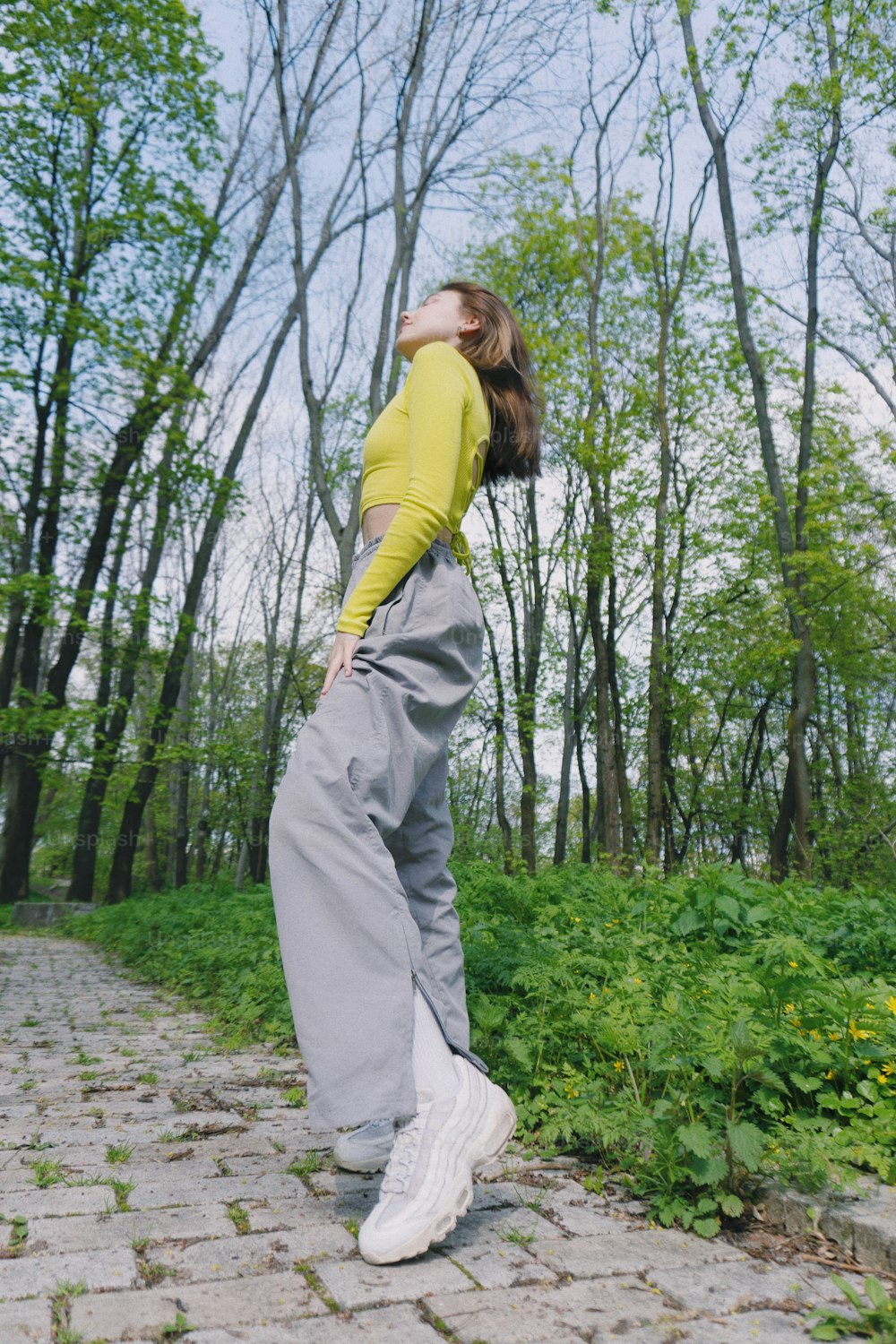 a woman in a yellow shirt and grey pants
