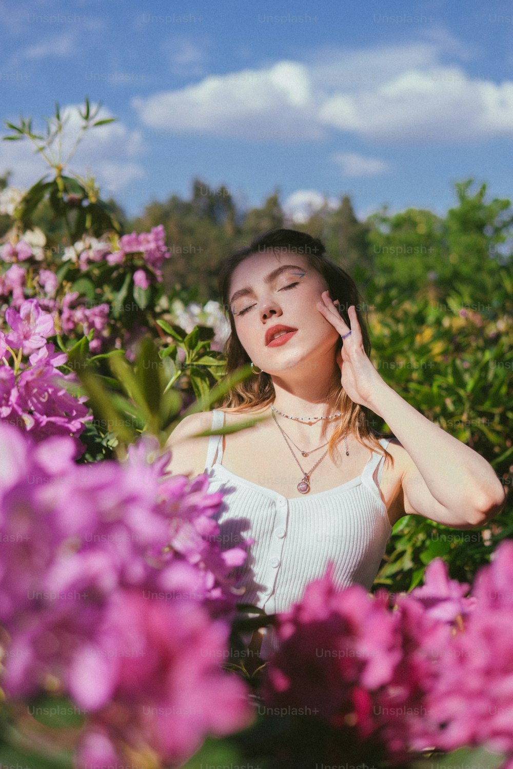 uma mulher em pé em um campo de flores roxas