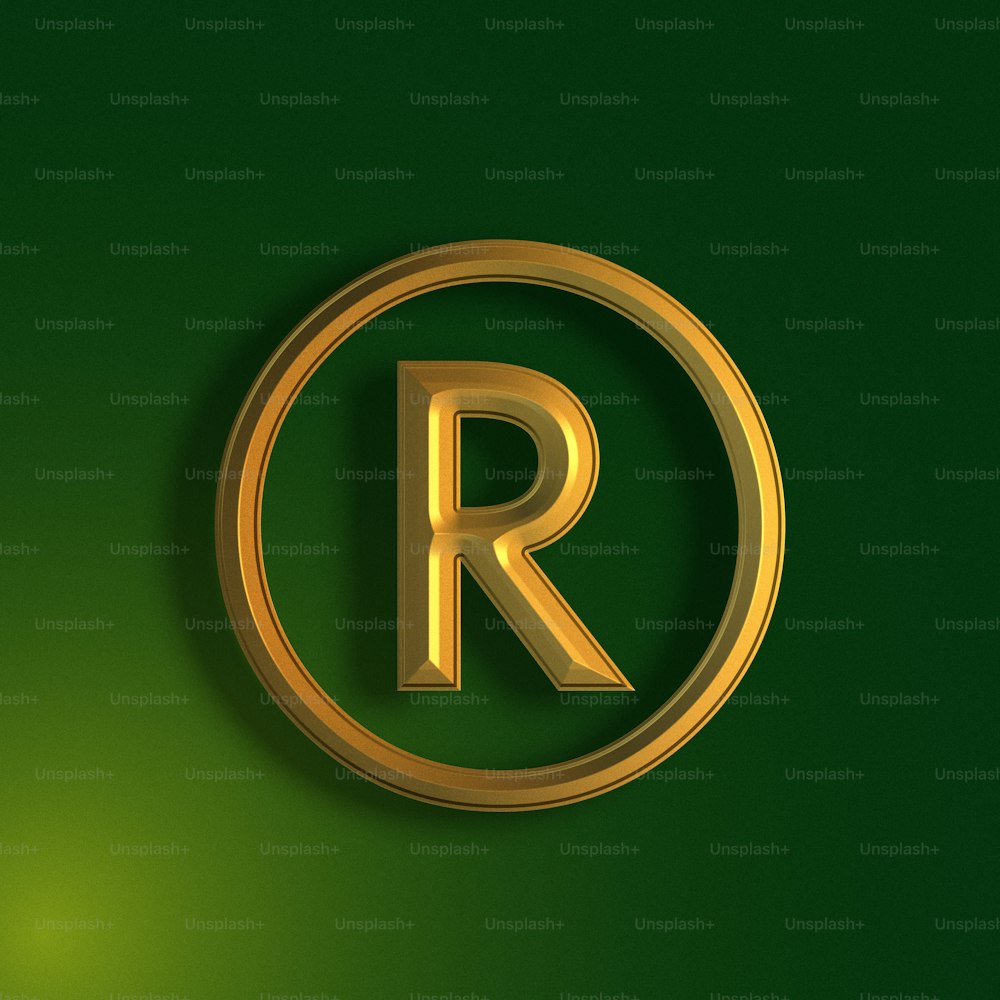 緑の背景に金色の円の中の文字R。