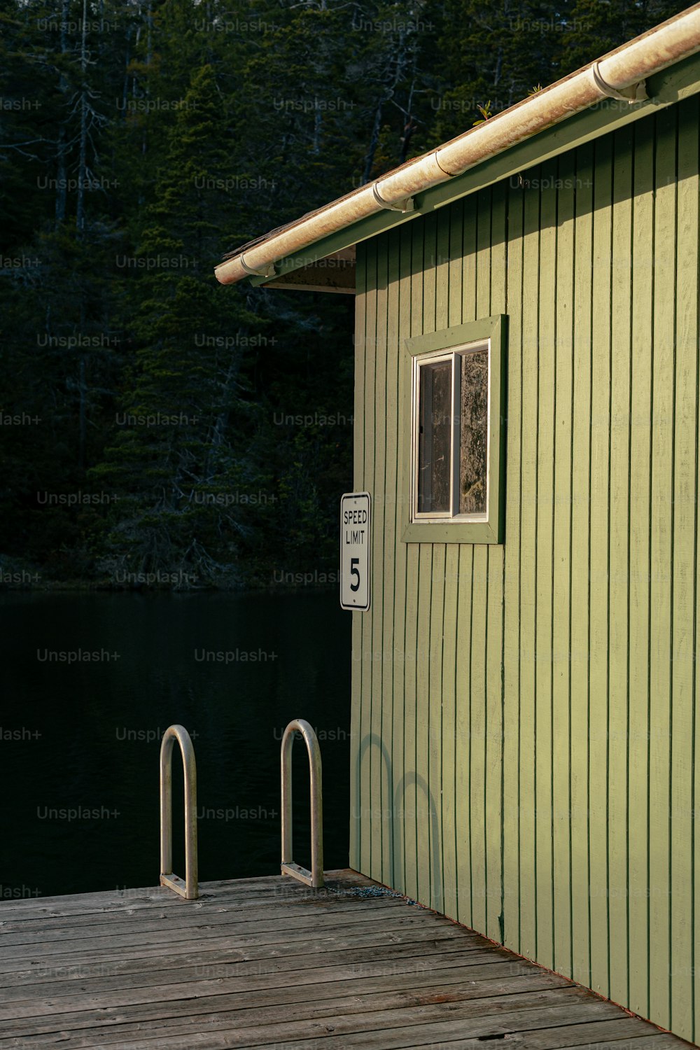 a wooden dock next to a green building