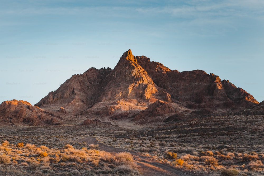 a mountain range with a dirt road in the foreground