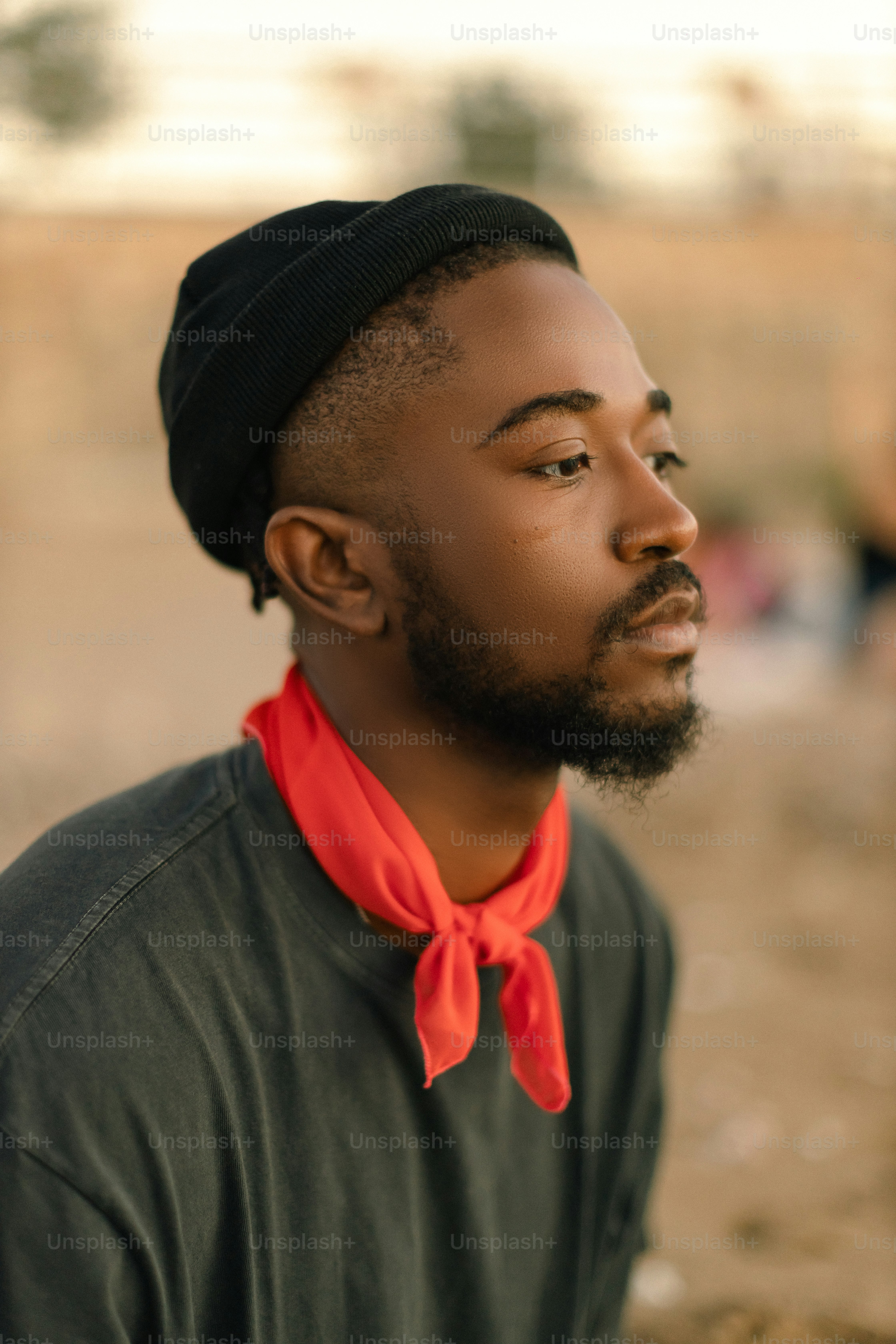 a black man with a red shirt and a black hat