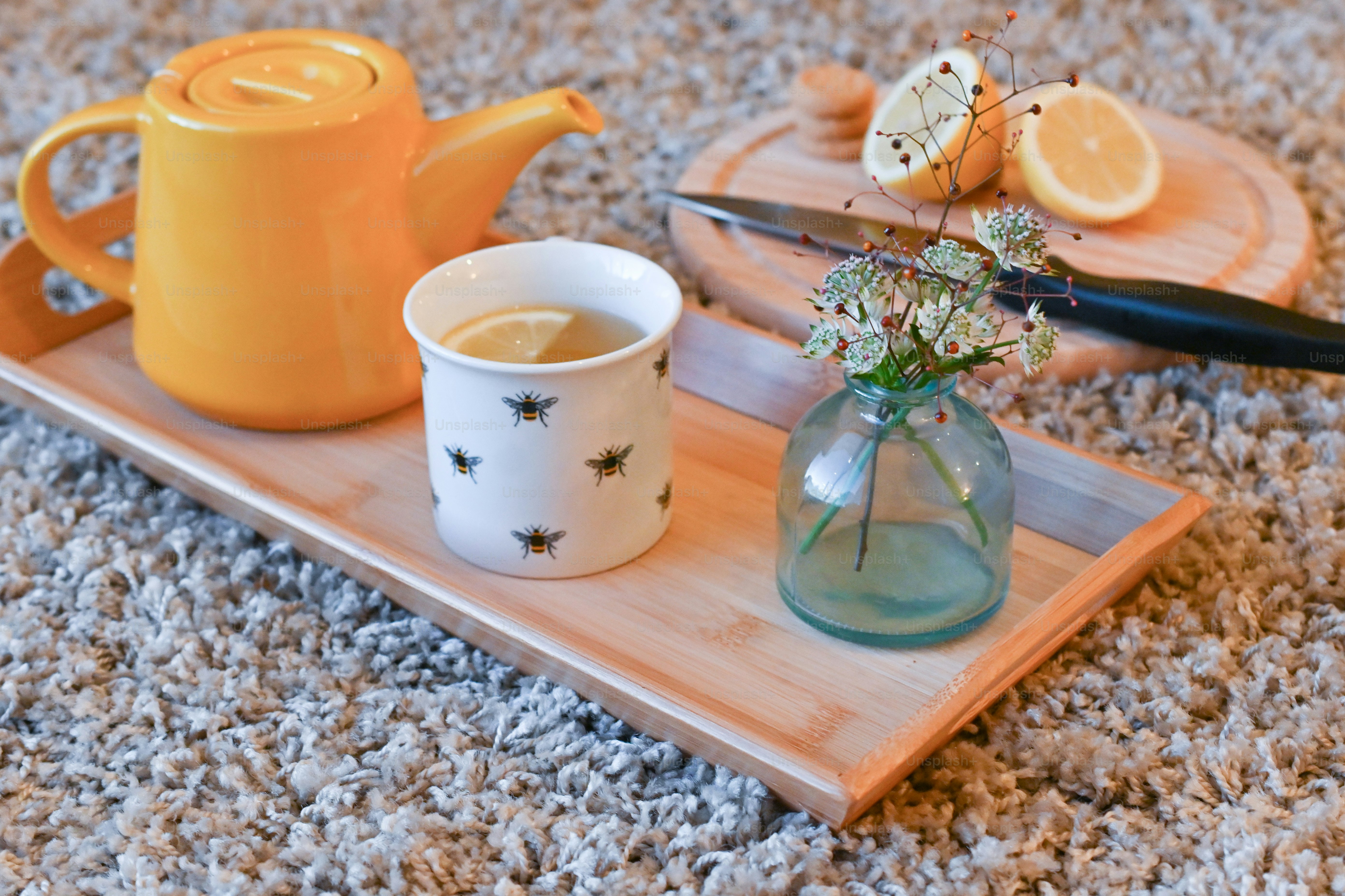 a tray with a vase of flowers and a teapot on it