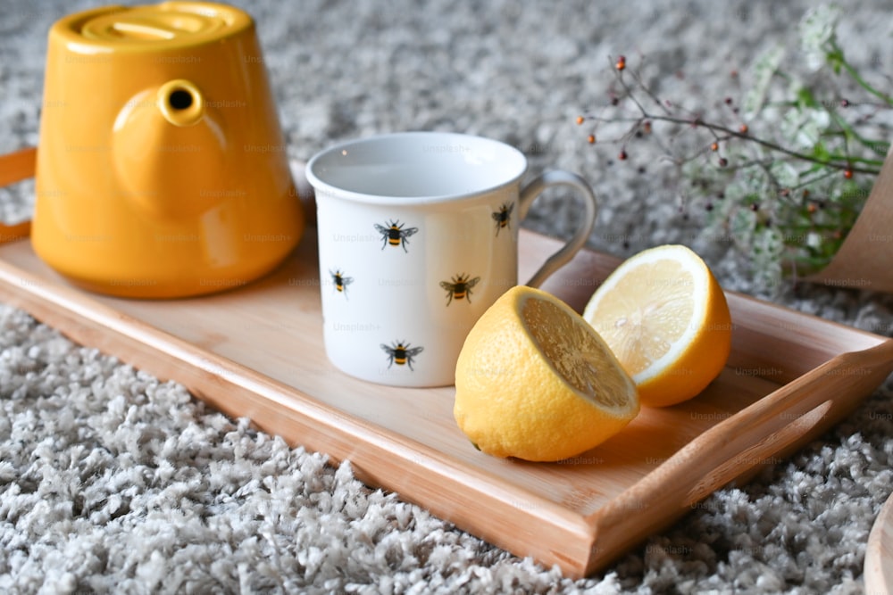 a tray with a lemon and a mug on it