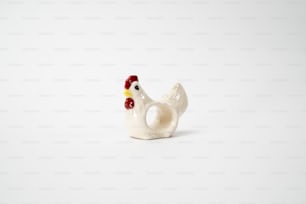 Una figura de gallo de cerámica blanca sobre un fondo blanco