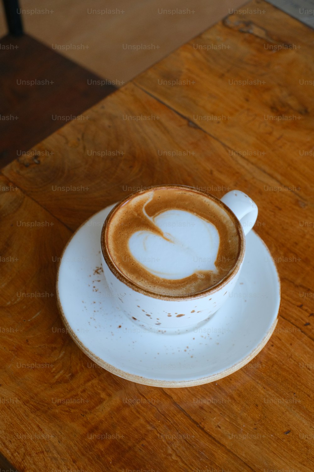 um cappuccino em um pires em uma mesa de madeira