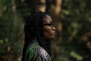 Una mujer con gafas parada en un bosque