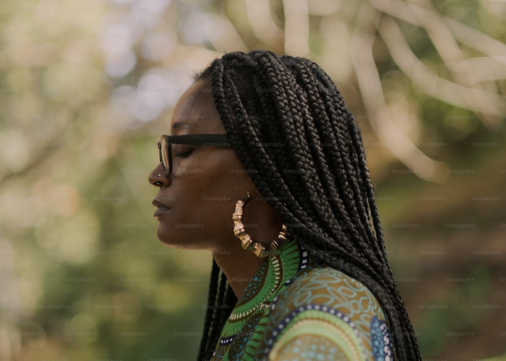 a woman with long braids wearing a colorful shirt