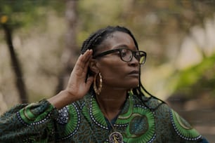 a woman wearing glasses and a green shirt