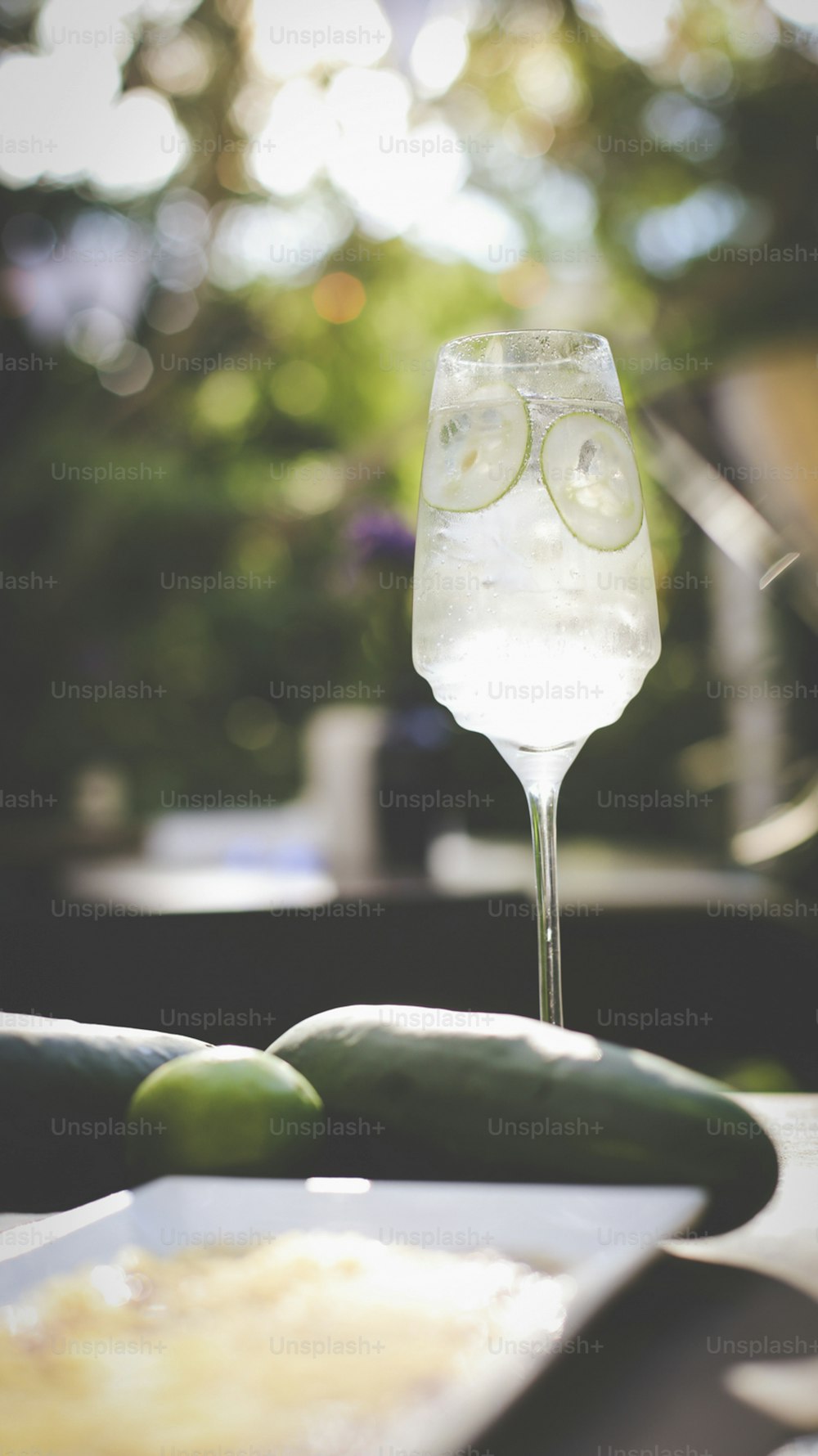 a cucumber and a glass of water on a table