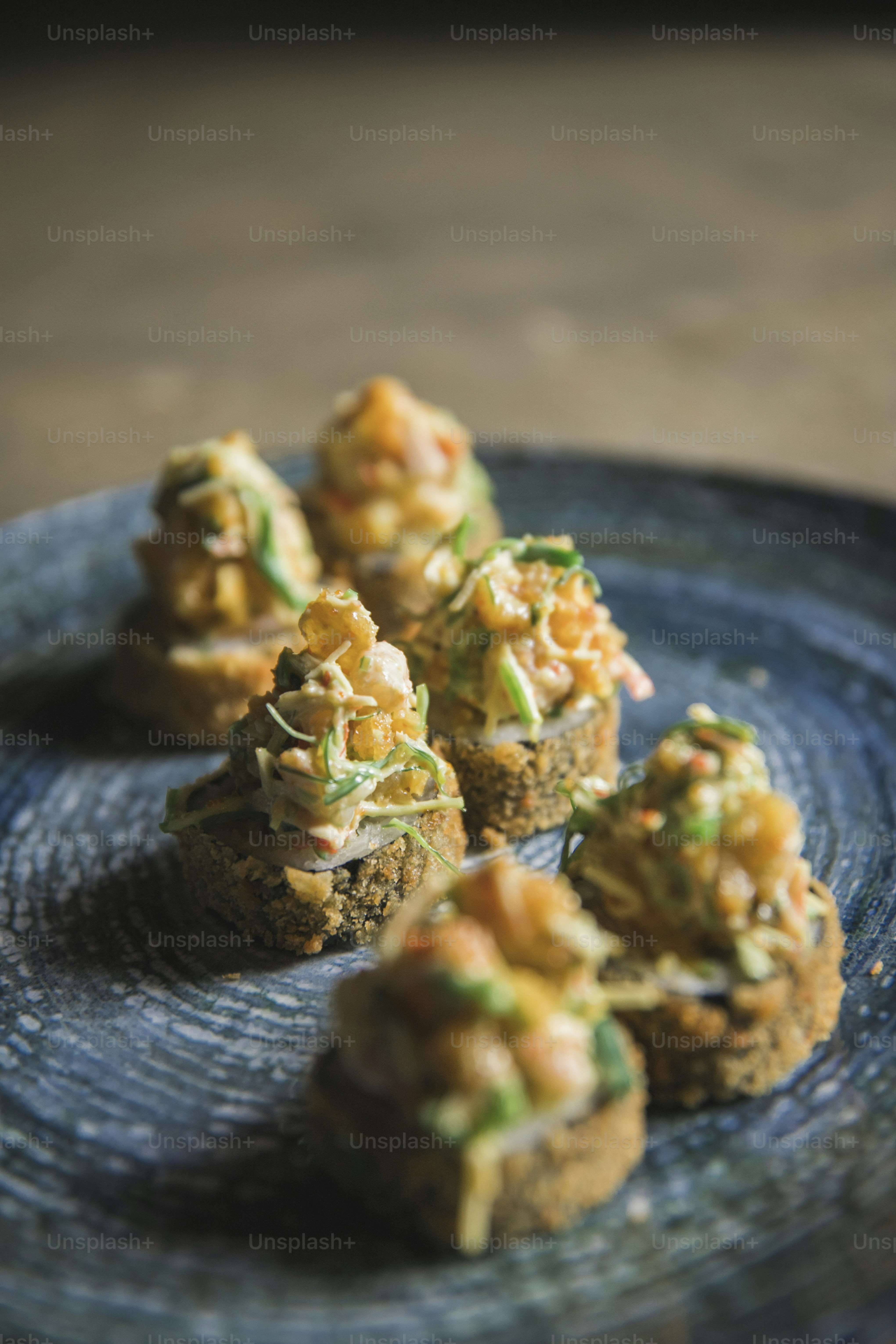 a blue plate topped with mini cakes covered in toppings