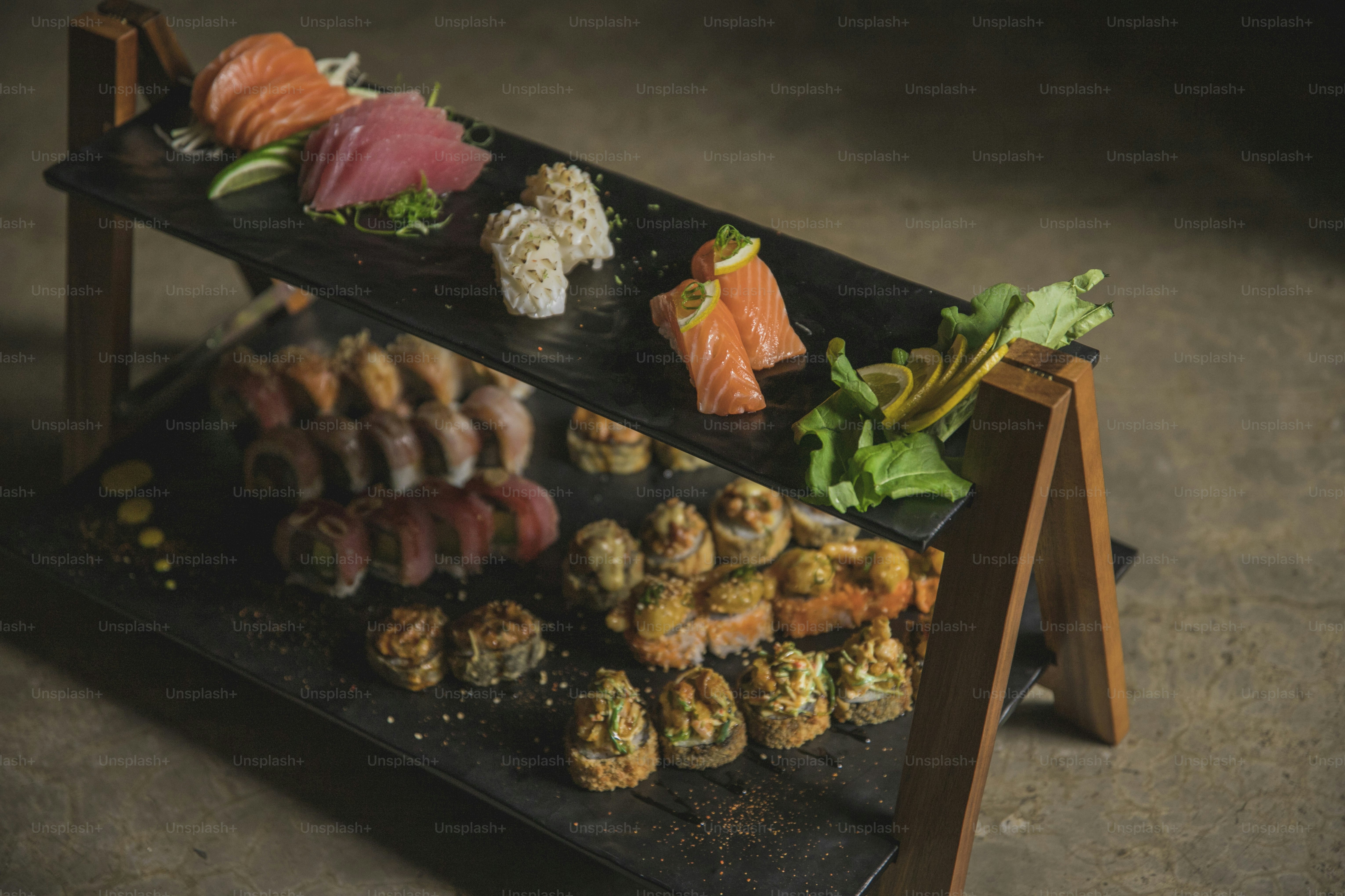 eine Präsentation von Sushi auf einem schwarzen Tablett