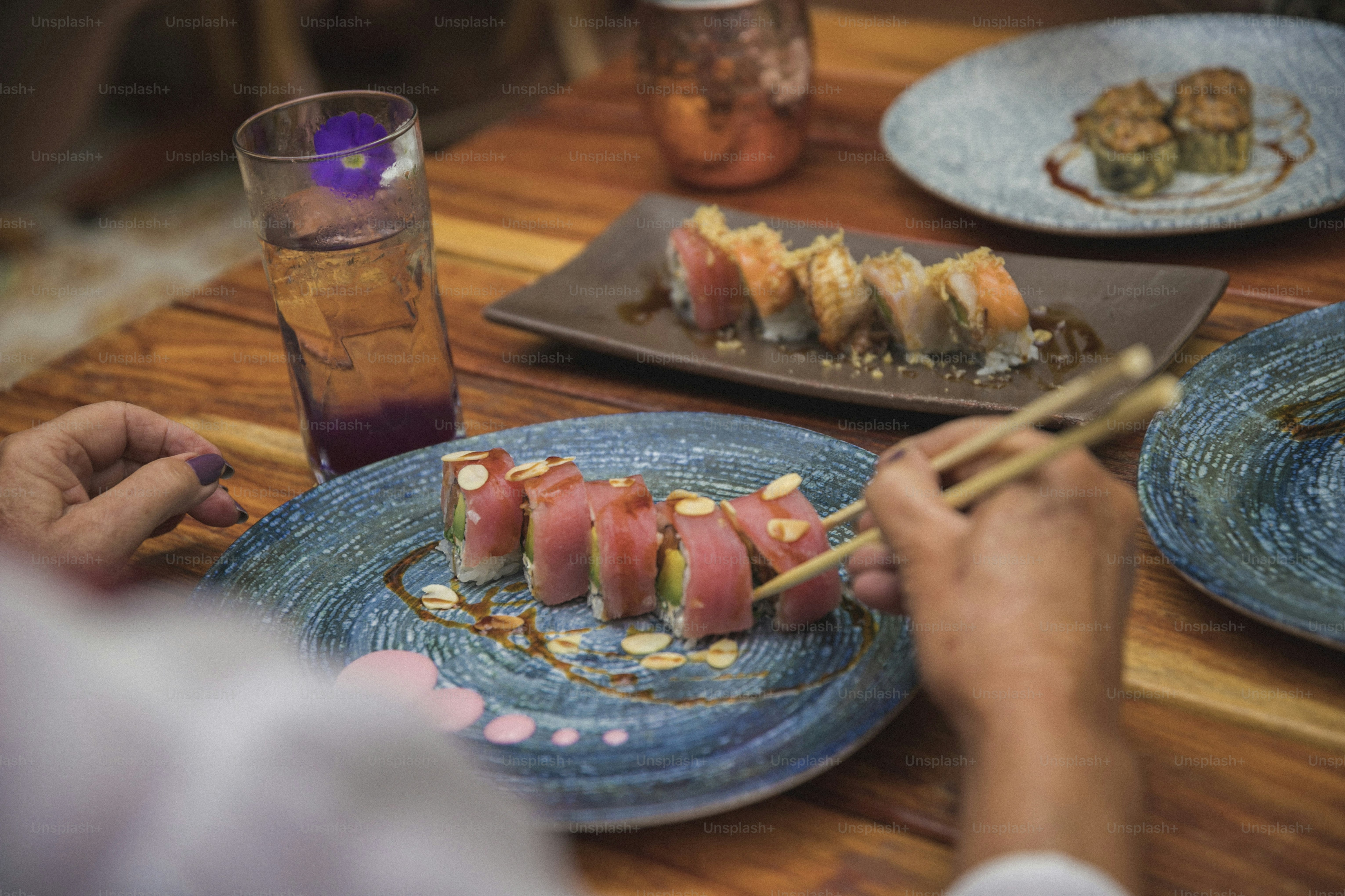 eine Person, die Sushi auf einem blauen Teller isst