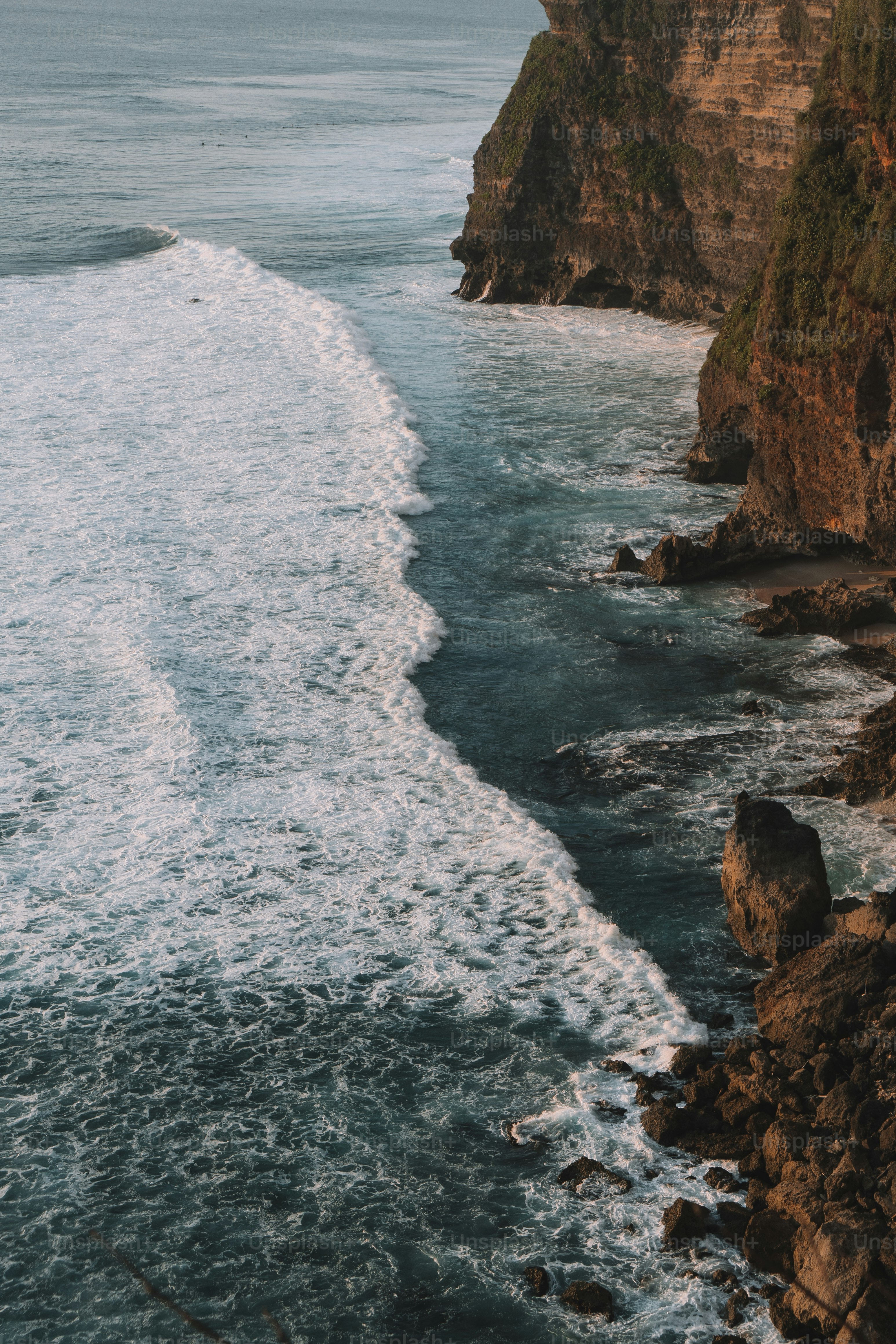 岩だらけの崖の隣にある大きな水域