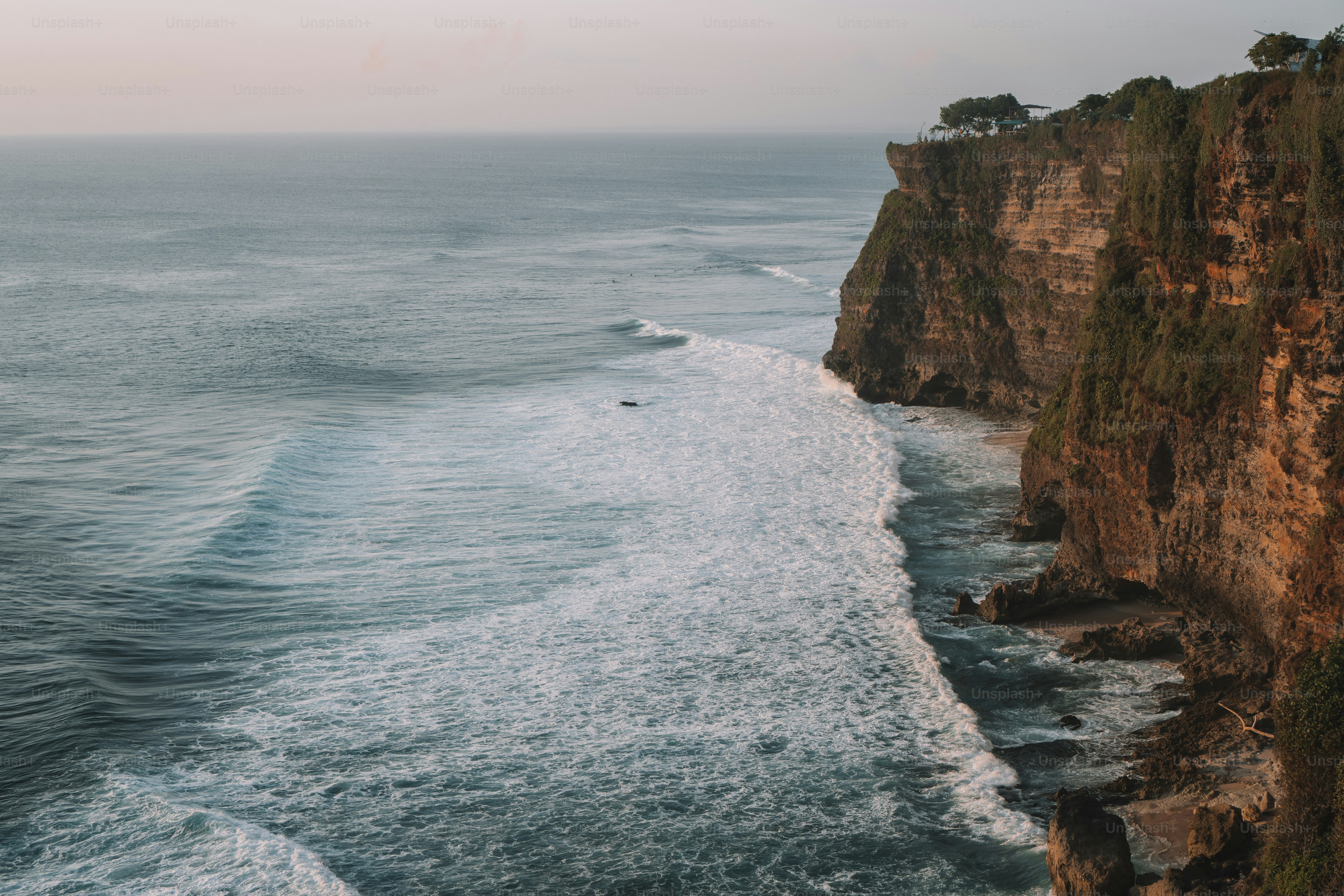 un grand plan d’eau à côté d’une falaise