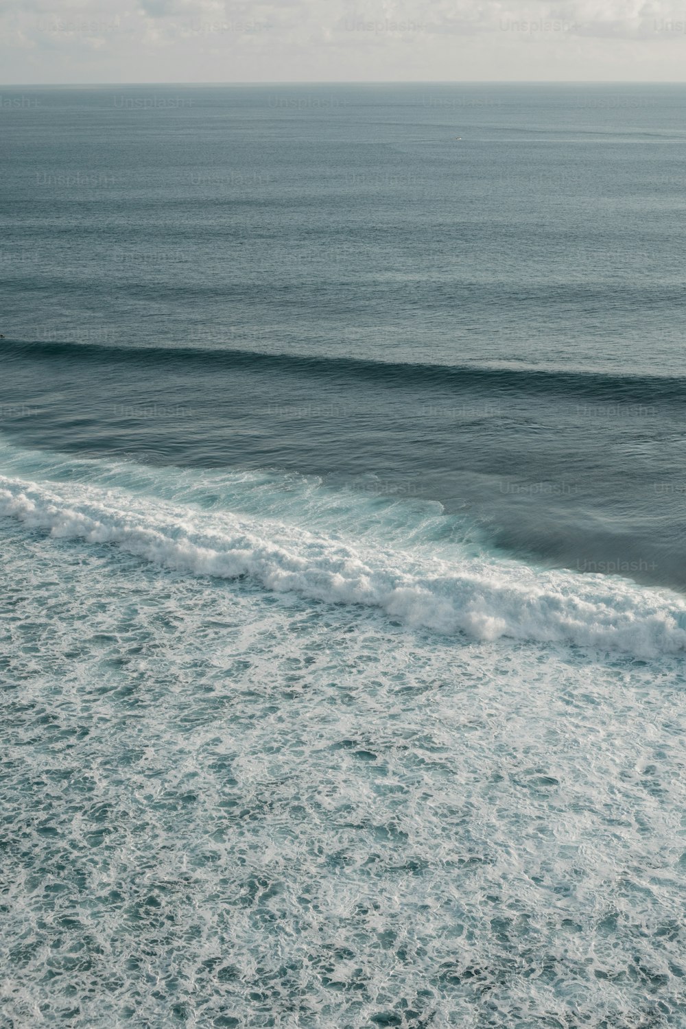 um homem montando uma prancha de surf em cima de uma onda