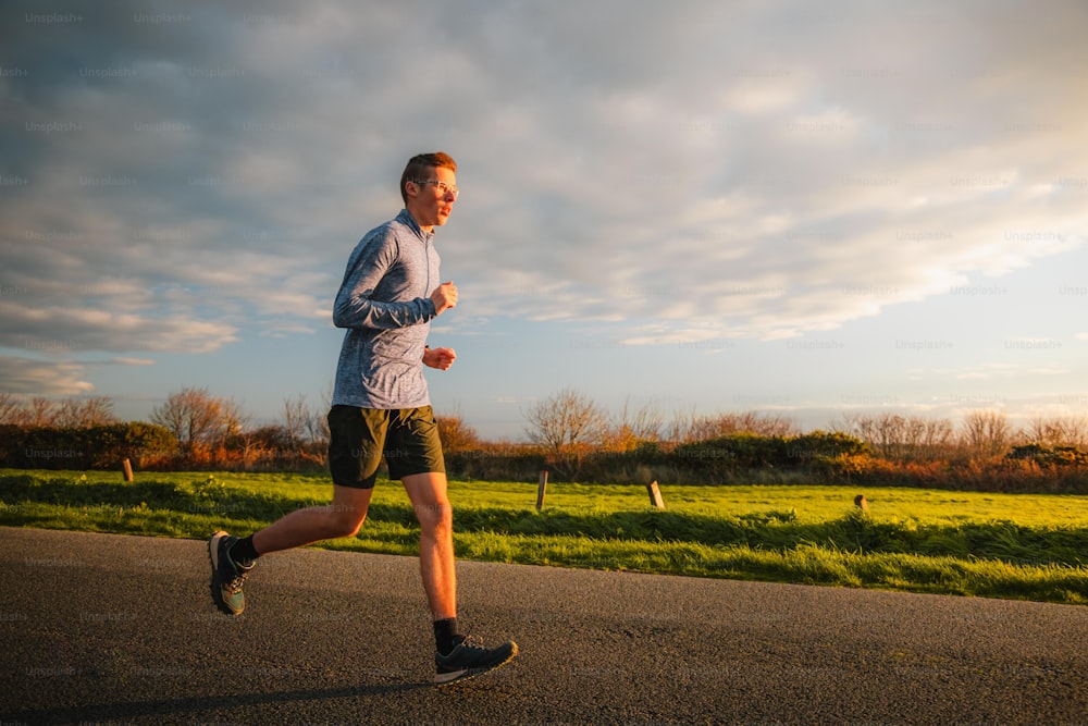 a man running down a road with a sky background