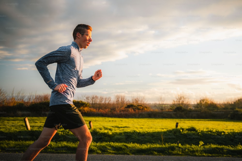 a man running on a road with a field in the background