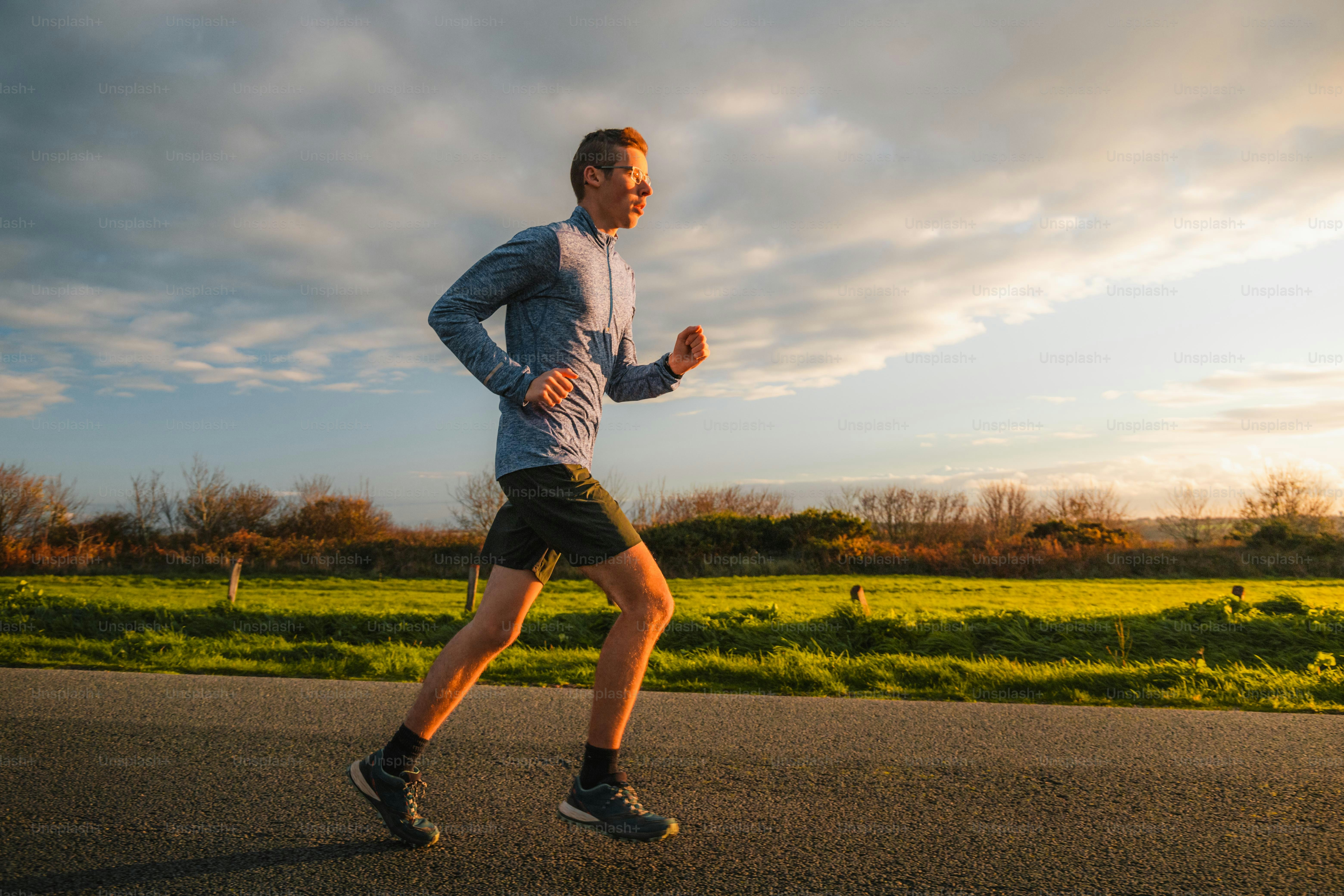 a man running down a road with a sky background