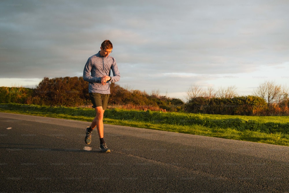 Un homme courant sur une route au milieu de la journée