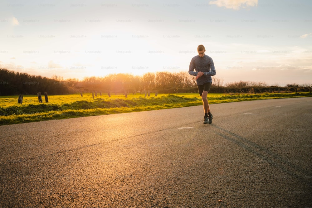 a man running down a road at sunset