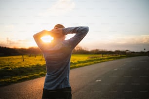 a man standing on the side of a road holding his hands to his head