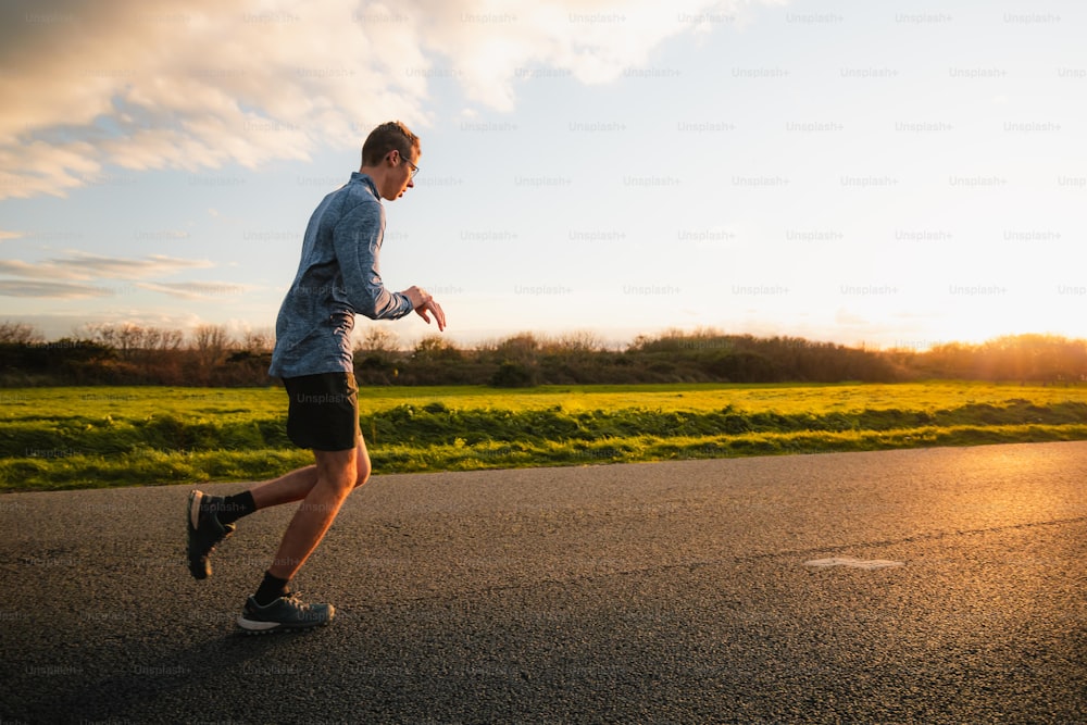 Un hombre corriendo por una carretera al atardecer