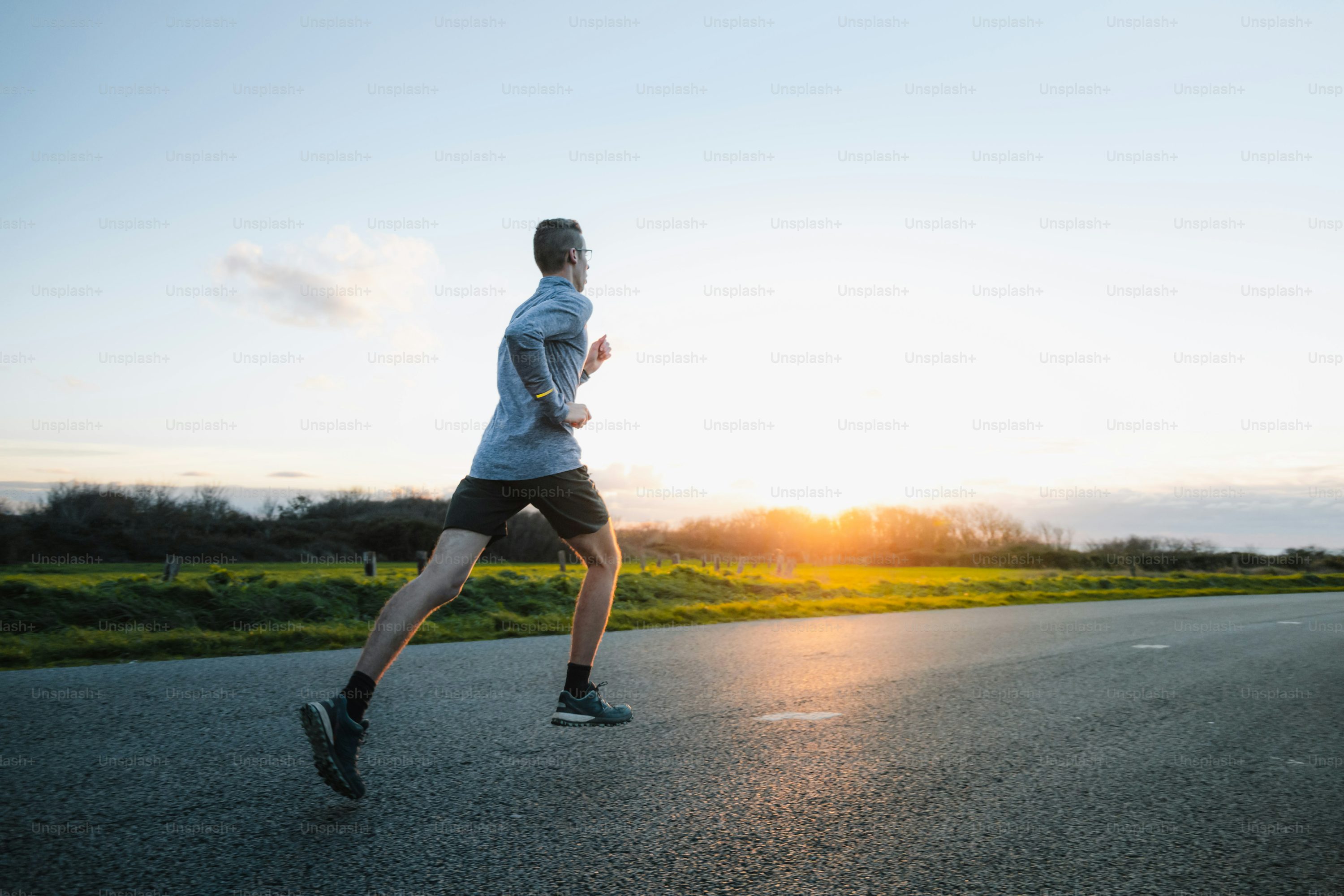 a man running down a road at sunset
