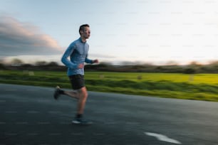 a man running down a road in a blue shirt